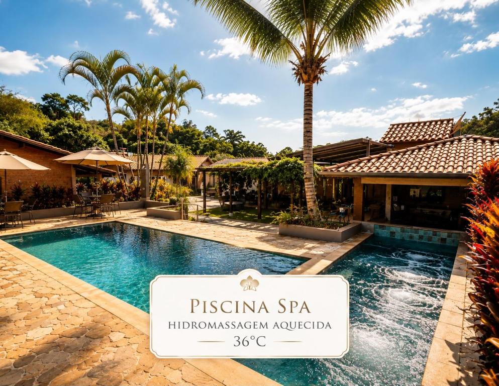 a swimming pool with a sign in front of a villa at Vale das Orquídeas Pousada in Socorro