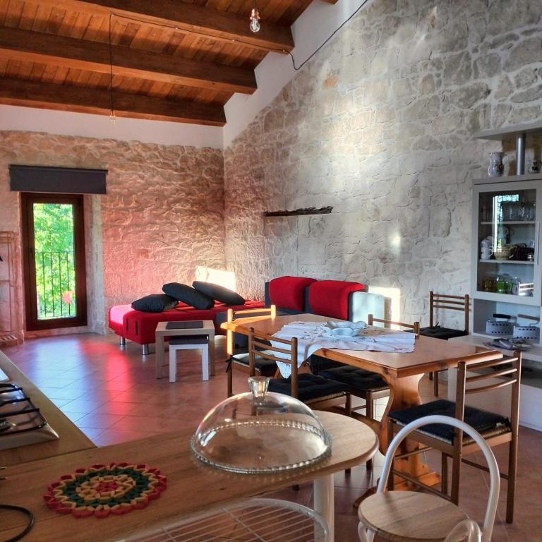a living room with a table and a red couch at Casa Rurale Pietra Bianca in Roccamorice