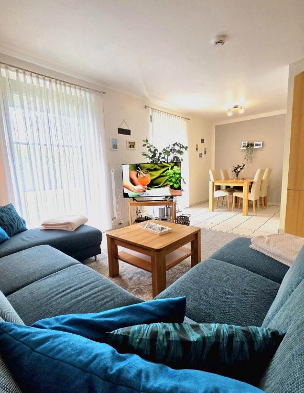 a living room with two blue couches and a table at Köhler-Glowienka, Ute App Nr 3 in Schönberger Strand