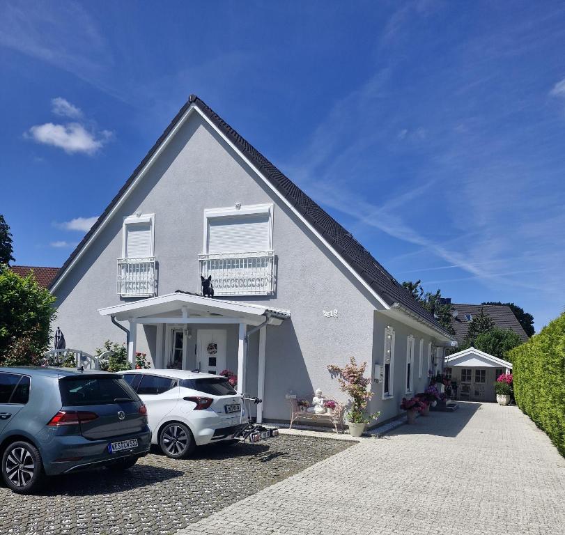 a house with two cars parked in front of it at Lilly & Fine in Zingst