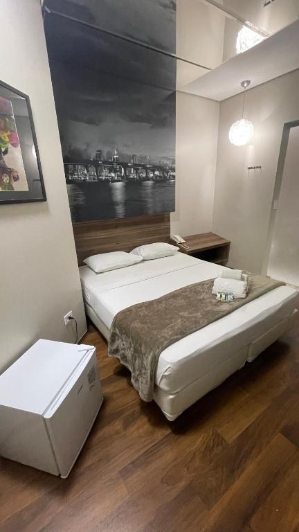 a bedroom with a large bed and a painting on the wall at Add Hotéis Center Norte in São Paulo