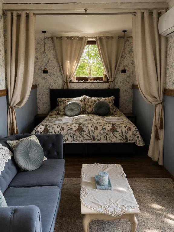 a bedroom with a bed and a couch and a window at Apartamenty Kapitańskie in Oława