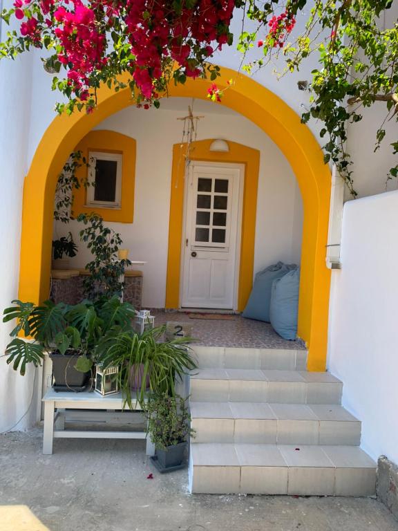 an archway with a door and a bench and flowers at Aegean Overlook Studios in Parikia