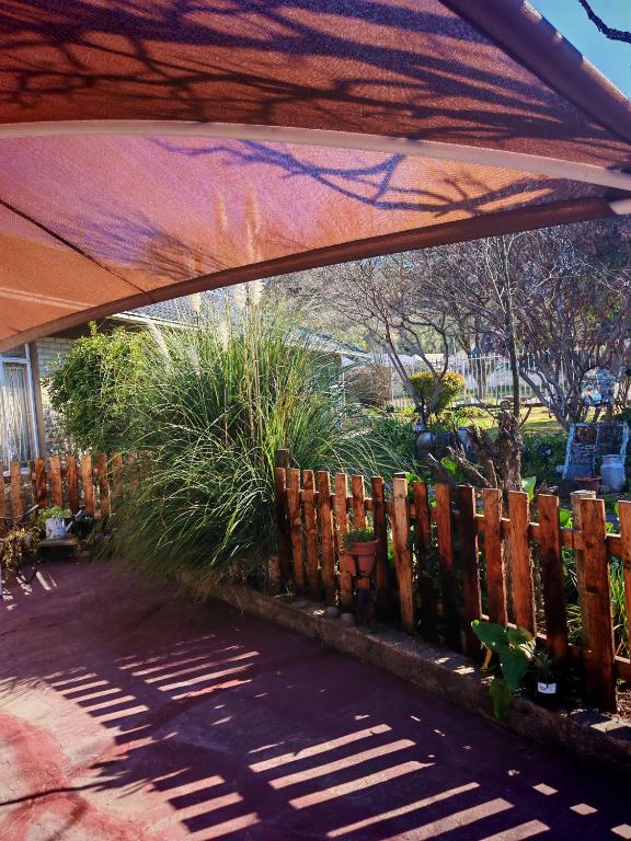 a patio with a wooden fence and a canopy at Habakkuk Guesthouse in Bethlehem