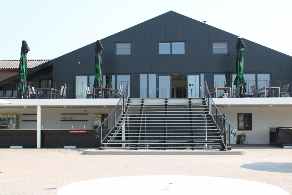 a black building with stairs in front of it at B&B Landgoed de Bossenhoeve in Schayk