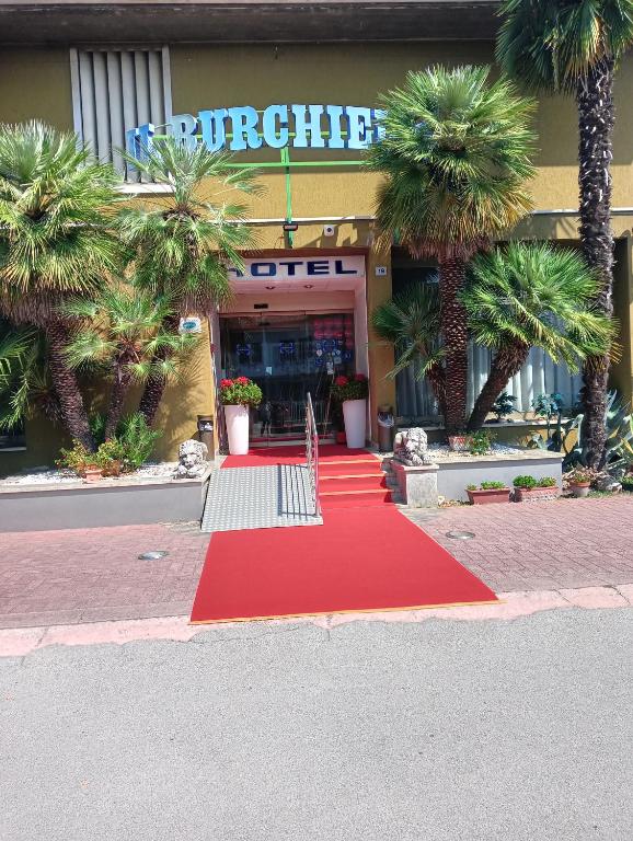a red carpet in front of a building with palm trees at Hotel Burchiello in Mira