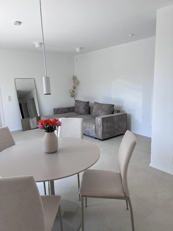 a living room with a table and chairs and a couch at Ferienwohnung Casa Panorama in Beuren