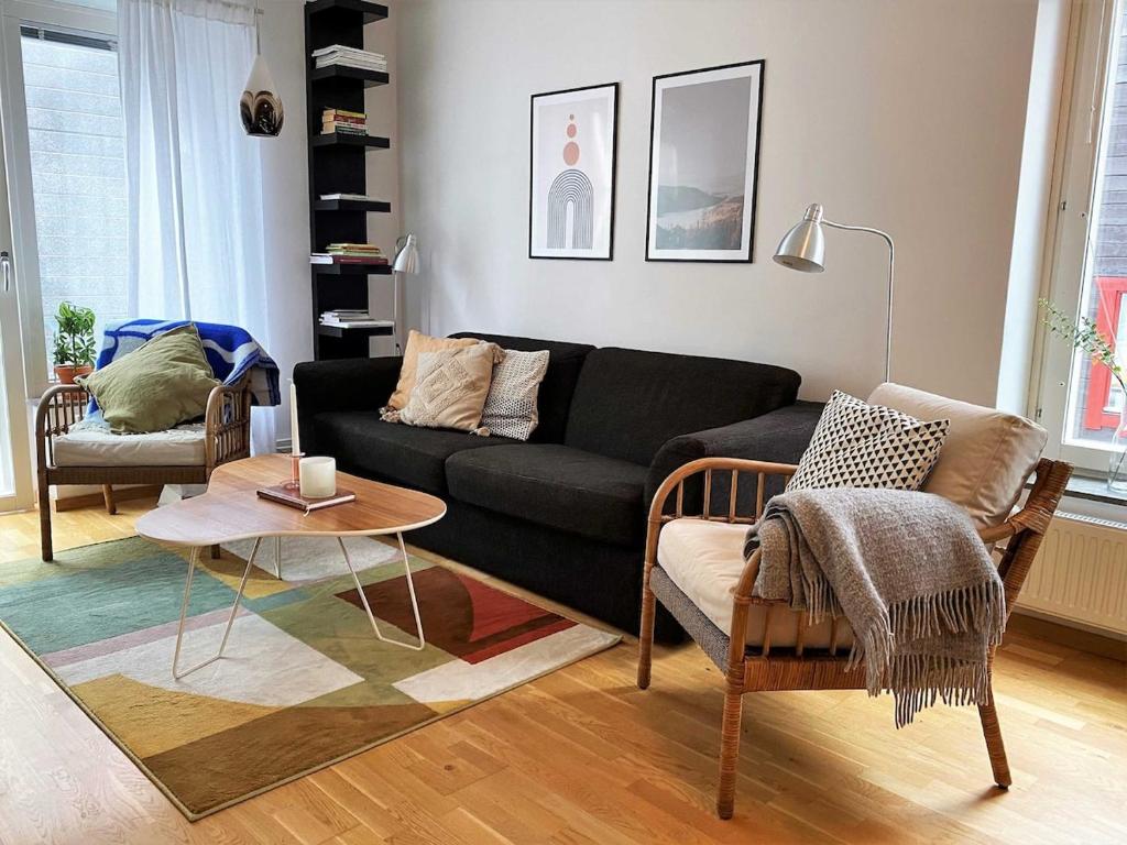a living room with a black couch and a table at Dählie Åre Torg Apartments in Åre