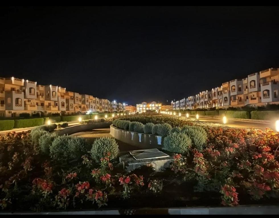 a row of houses at night with bushes and lights at Nozha Beach للعائلات in Ras Sedr