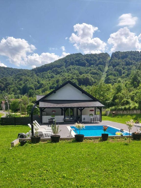 a house with a gazebo and a swimming pool at Vikendica Lohovo in Bihać