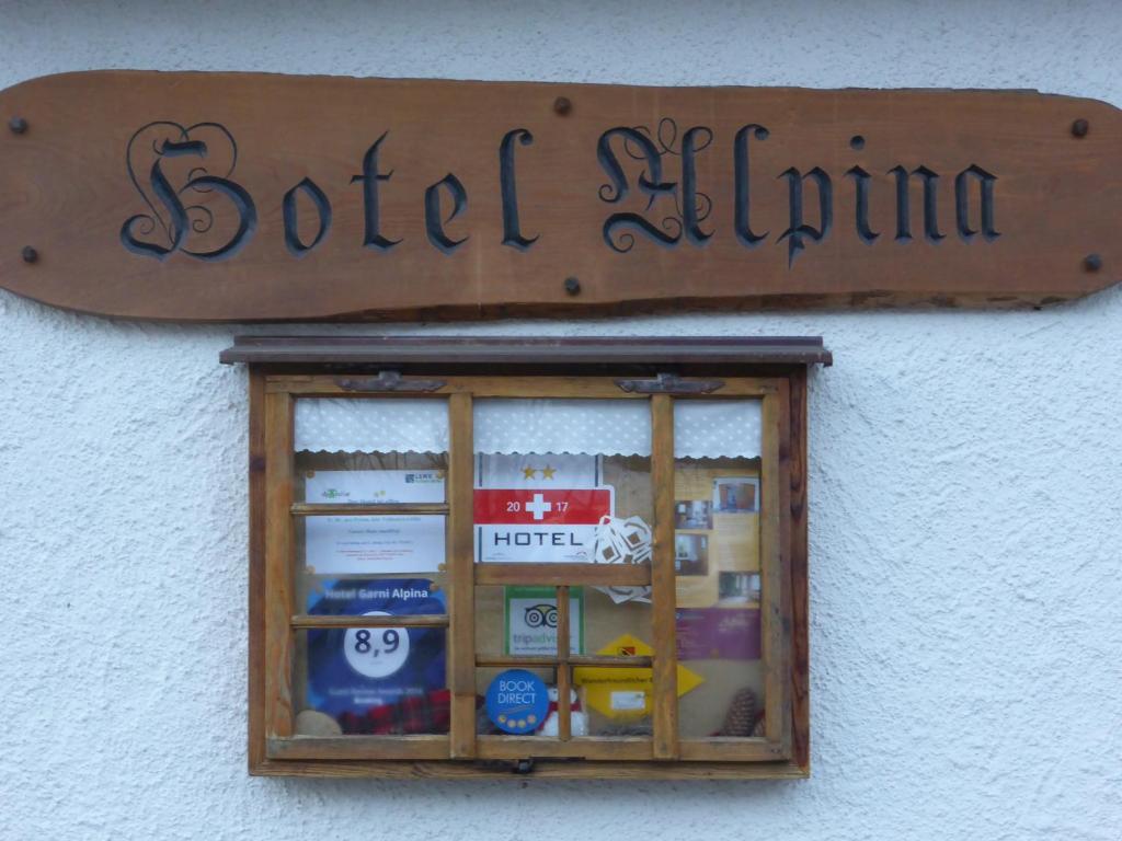 a sign above a window of a building at Pension Alpina in Lenk