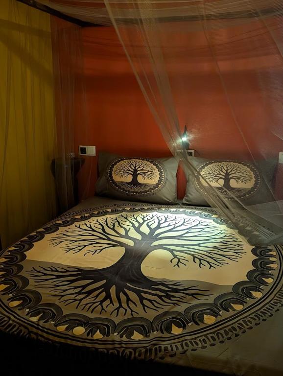a bed with a tree painted on the comforter at ZenGardenCV in Lazareto