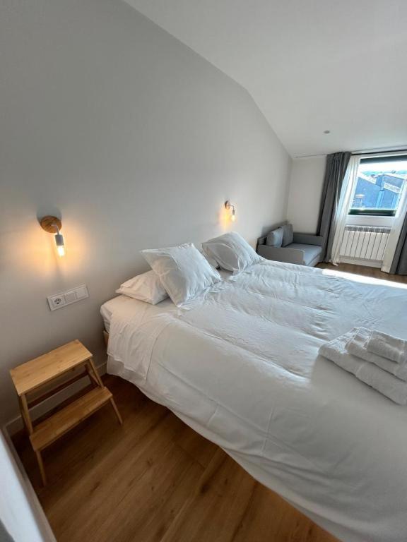 ein großes weißes Bett in einem Schlafzimmer mit Fenster in der Unterkunft Pensión do Catro in A Pobra de Trives