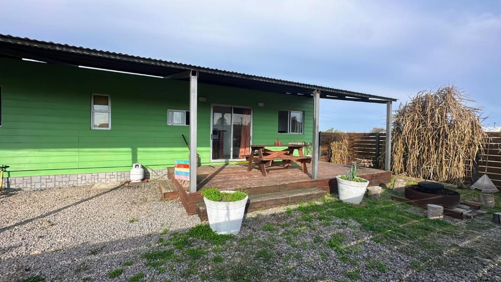 a green house with a picnic table on a patio at Aurora in Carmelo