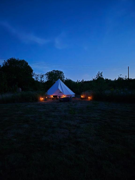 a tent in the middle of a field at night at Lyng Farm Campsite in Brisley