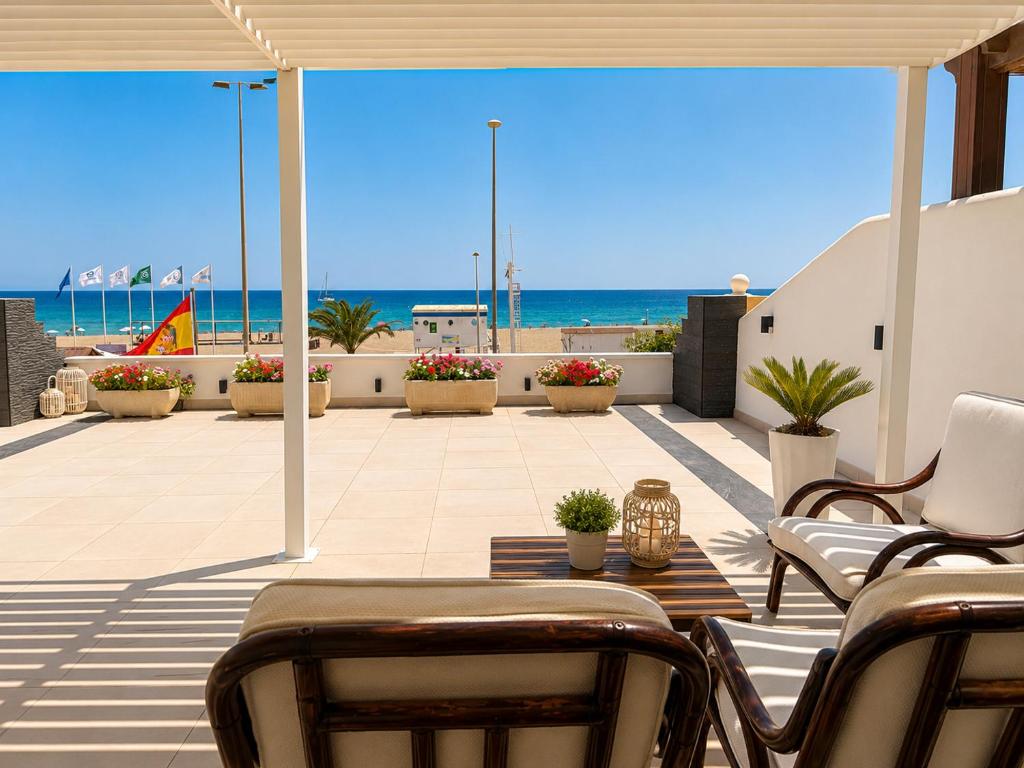 a patio with chairs and a view of the beach at Villa Dru in Roquetas de Mar