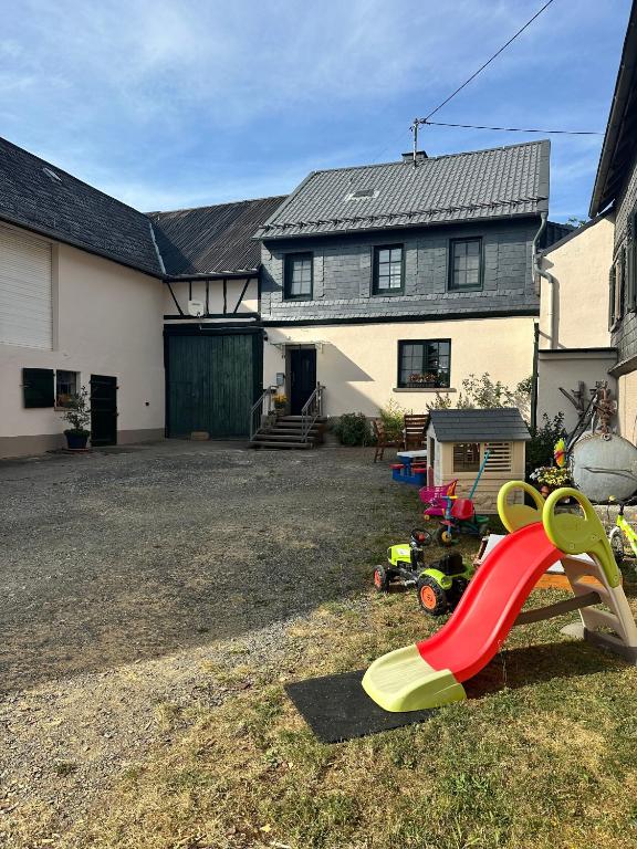a house with a yard with a red slide at Schmidnickels Hof in Schwarzerden