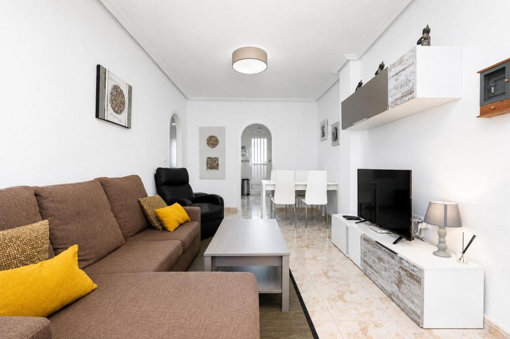 a living room with a couch and a tv at Playa del Pinet Apartment in La Marina
