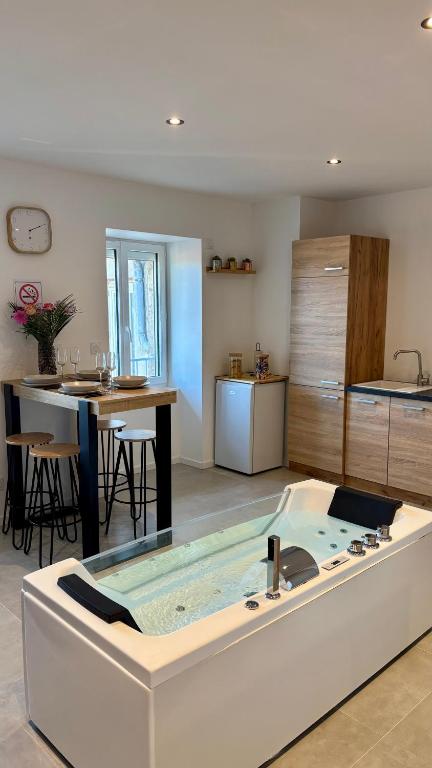 a room with a bath tub in the middle of a kitchen at Studio Cocon & Bulle in La Côte-Saint-André