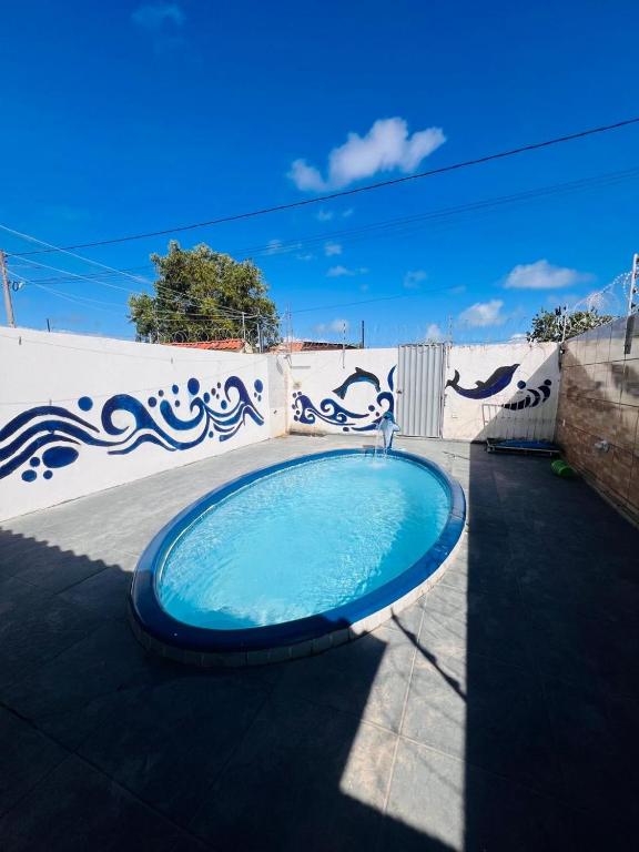 a large blue swimming pool in front of a fence at MT Laser casa 2 in São José da Coroa Grande