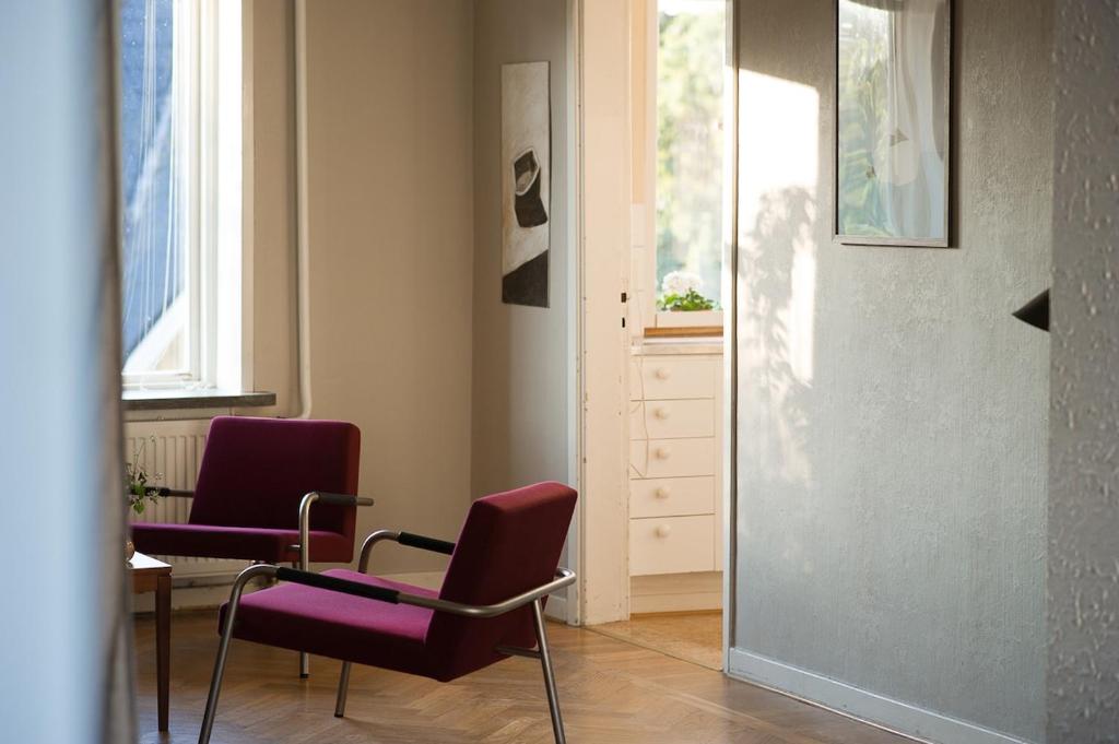 a room with two chairs and a table and windows at Spjutstorp's old school and rectory, 1 in Tomelilla