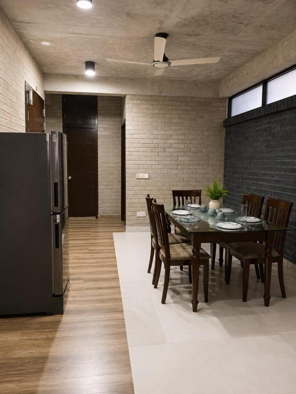 a dining room with a table and a refrigerator at HomeWay Dhaka in Kāmarpāra