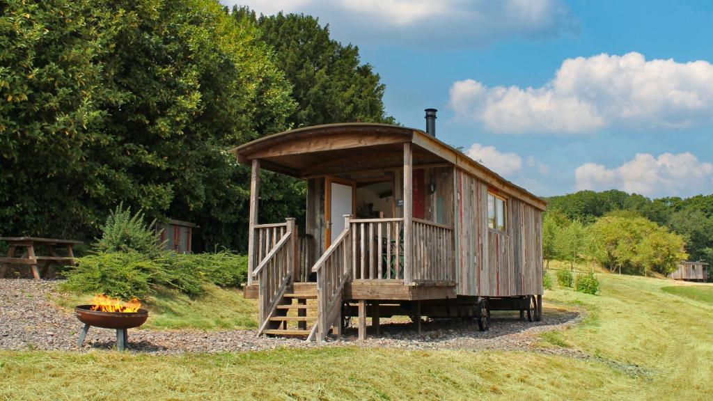 a small cabin with a porch and a bowl of fruit at Betty Shepherd's Hut in Lydney
