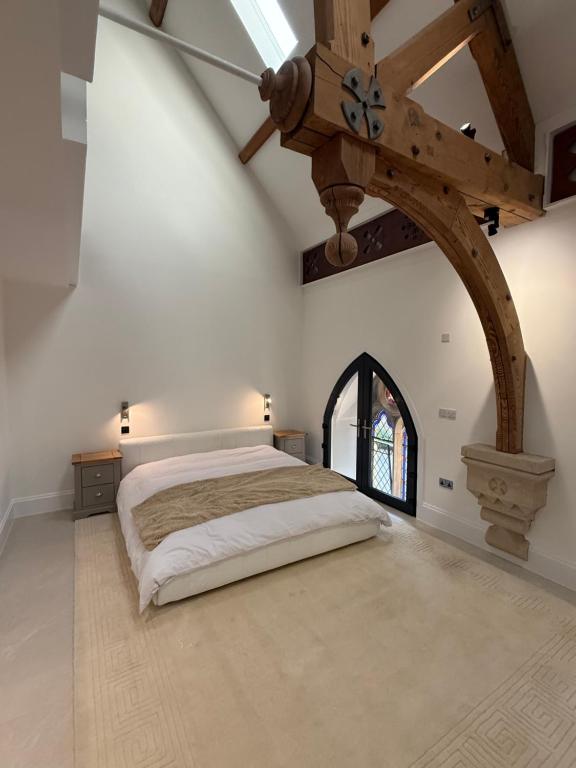 a bedroom with a large bed with a wooden ceiling at The North Wing in Stotfold