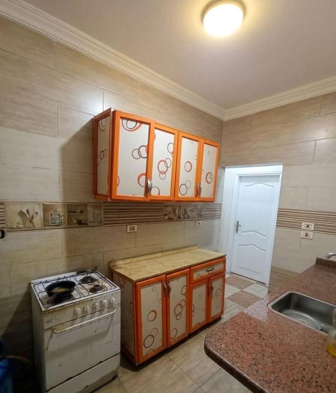 a kitchen with a stove and cabinets and a sink at Sami apartment in Alexandria