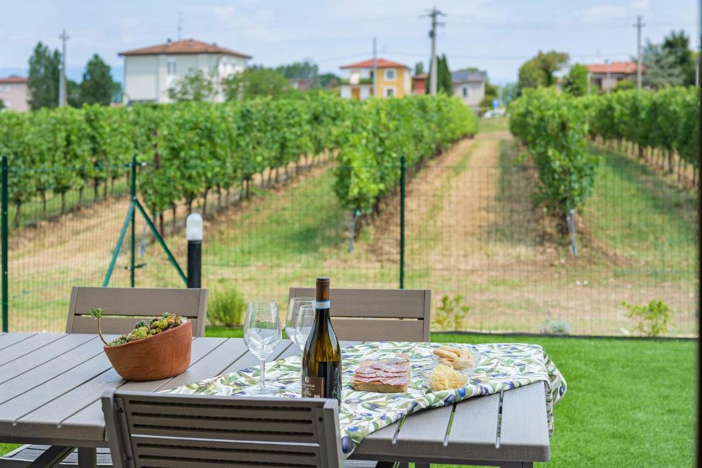 a table with a bottle of wine and wine glasses at Katy Lake Timo in Sirmione