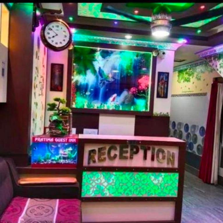 a room with a aquarium with a clock and a bench at Hotel Protima guest inn in Digha