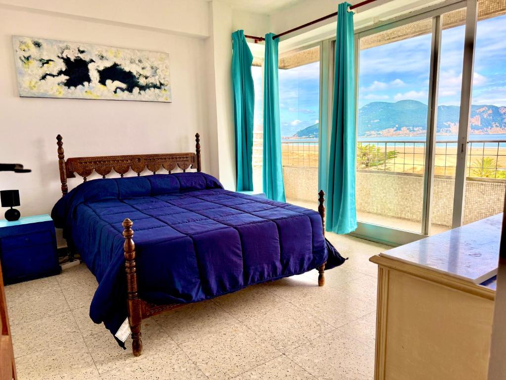 a bedroom with a bed with blue sheets and windows at Apartment Laredo Sea Beach in Laredo