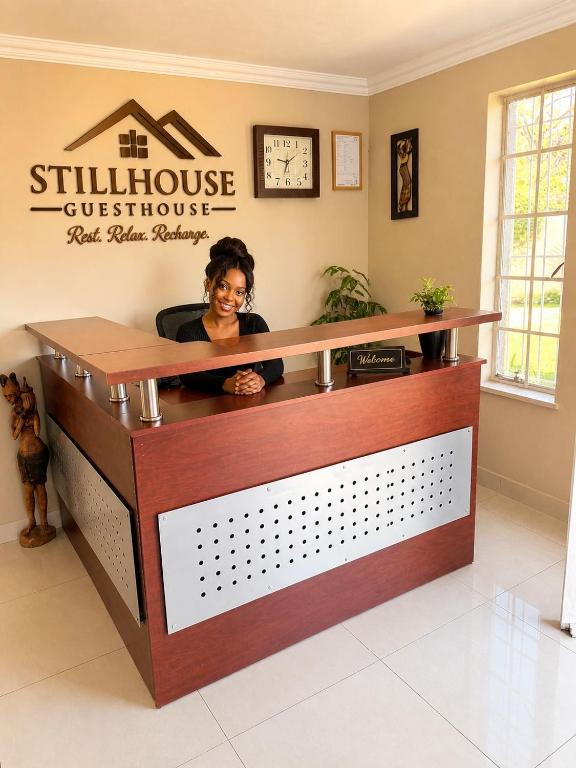 a woman sitting at a salon reception desk at The Stillhouse Guest House in Edenvale