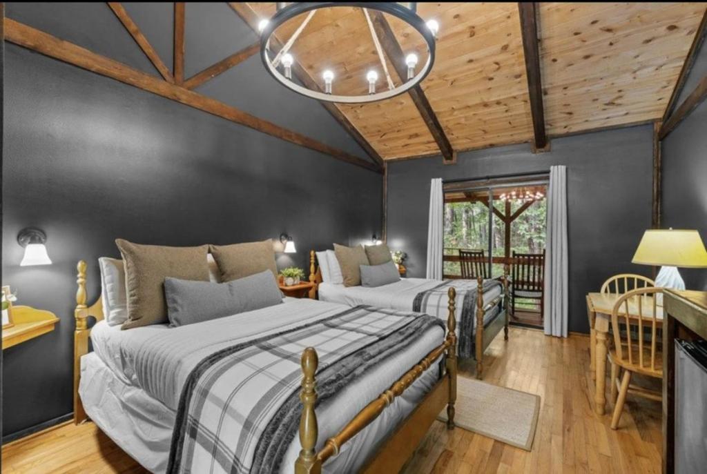two beds in a room with wooden ceilings at The Lost Compass in Sautee Nacoochee