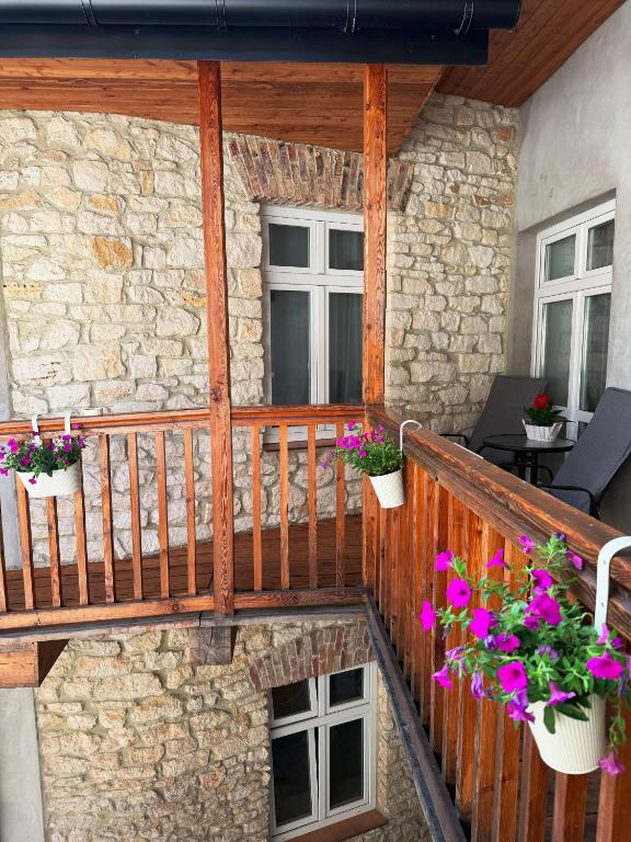 a balcony with potted flowers on a stone wall at Apartamenty Stare Podwórko in Pilica