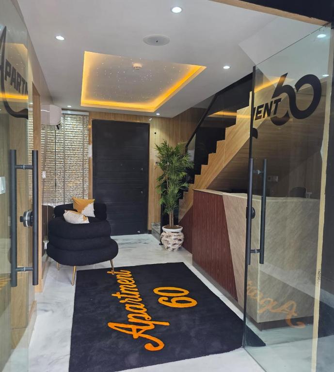 a lobby with a staircase and a chair and a carpet at Apartment60 in Lagos