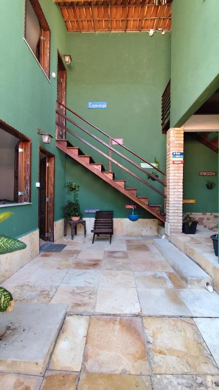 a green building with a staircase and a bench at Pousada Preguiça in Canoa Quebrada