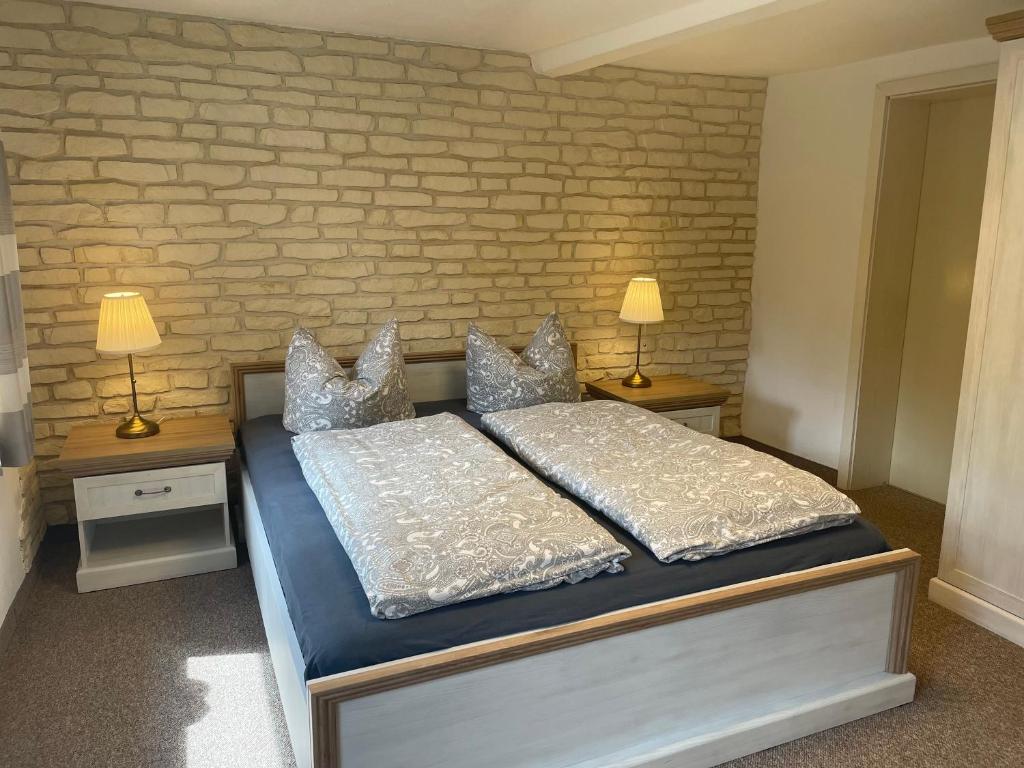 a bedroom with a bed with two tables and two lamps at Am Holundergrund in Kurort Gohrisch