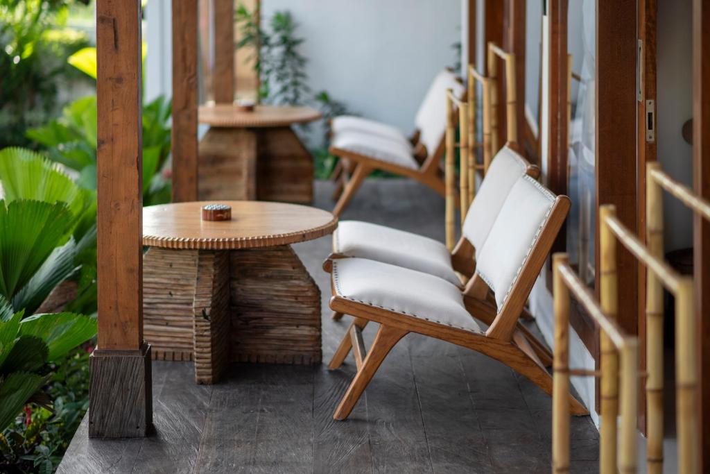 a porch with two chairs and a table at Dream Nest Bali in Munggu