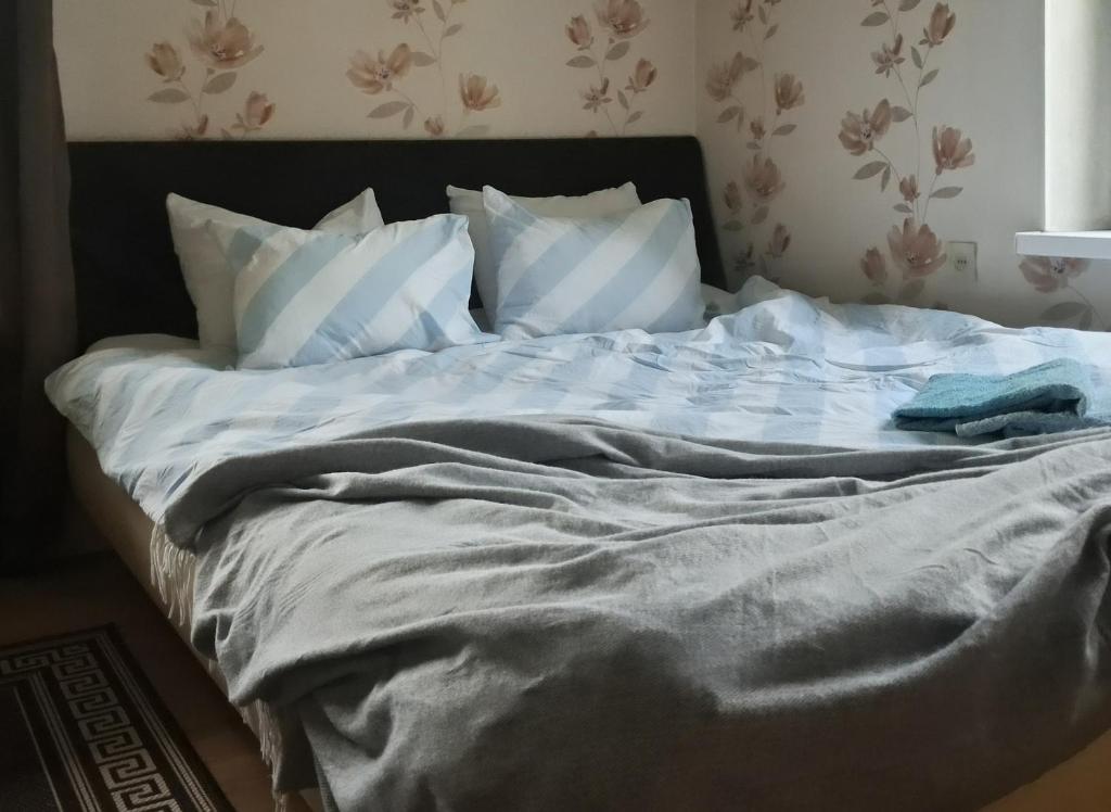 an unmade bed with a blanket and pillows at Heinamaa Lodge with sauna in Lammasküla