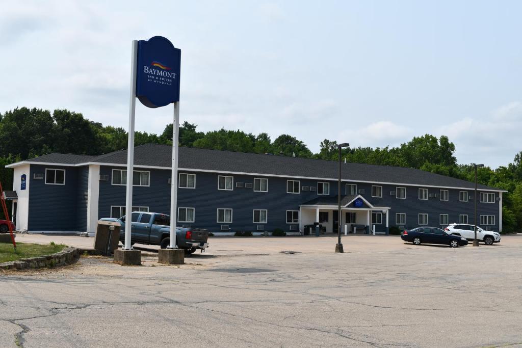 a large building with a flag in a parking lot at Baymont Inn And Suites by Wyndham Platteville in Platteville