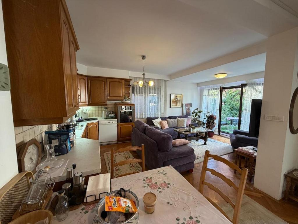 a kitchen and living room with a couch and a table at Safely located apartment in Prishtinë