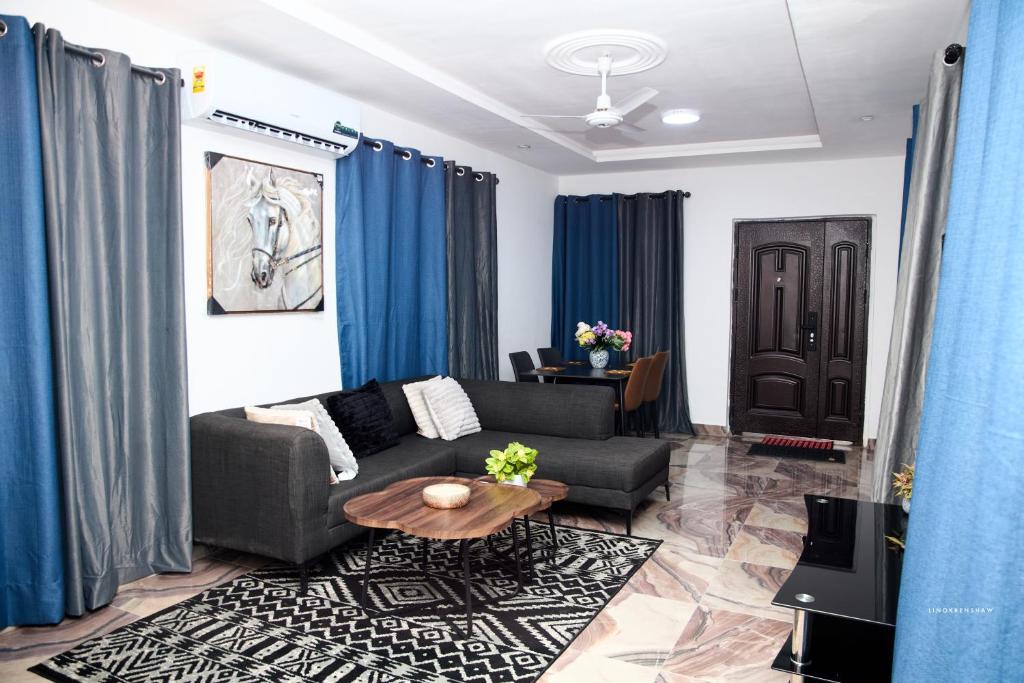 ein Wohnzimmer mit Sofa und Tisch in der Unterkunft Motion apt in Accra