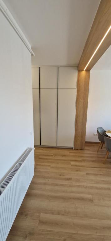 an empty room with white walls and wood floors at Forest Nest - Livezeni in Livezeni
