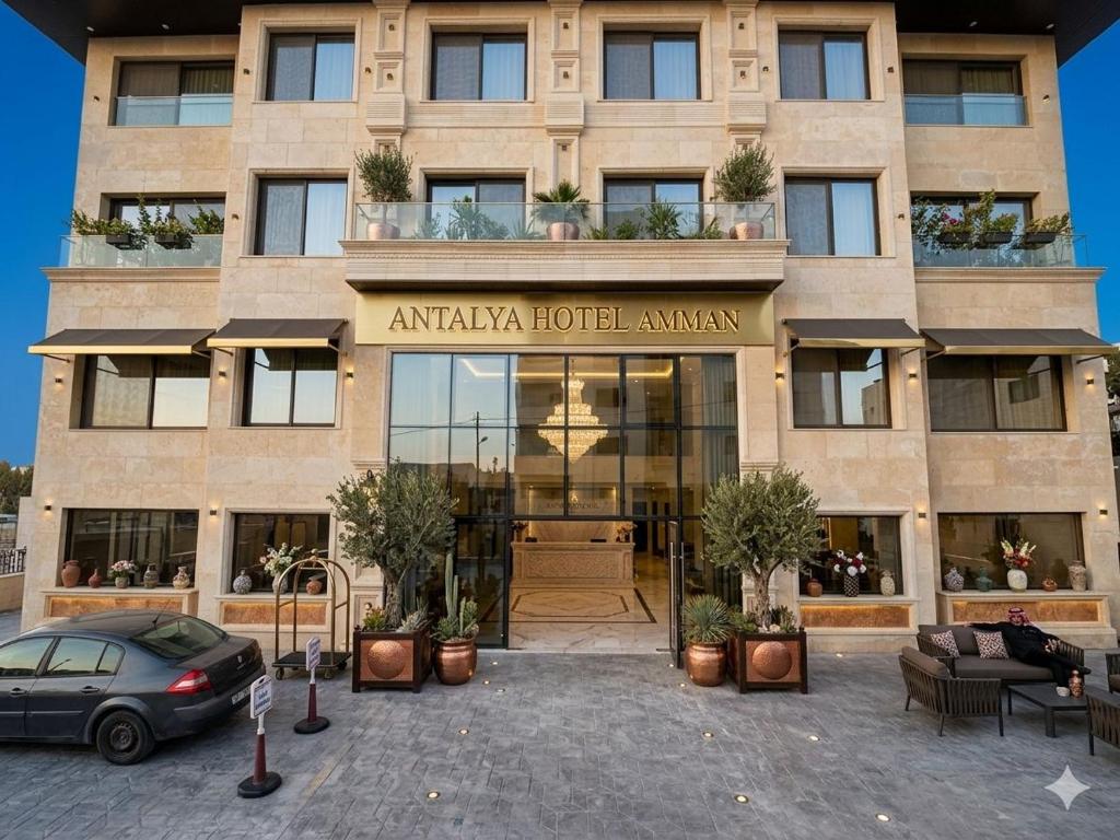 a building with a car parked in front of it at Antalya Hotel Am in Amman
