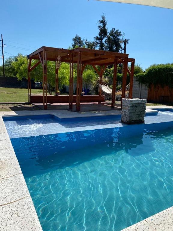 a swimming pool with a gazebo in the background at Finca Alta Gracia La Banda in La Banda