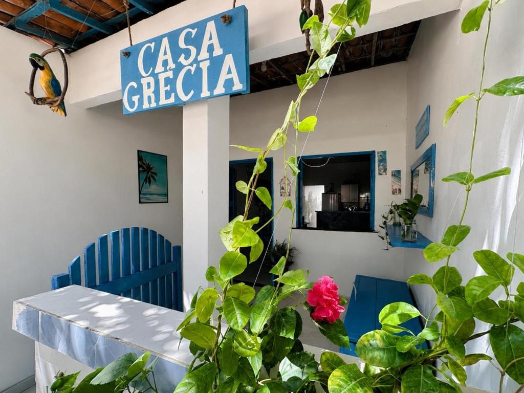 a sign for a casa grecia with a plant at Casa Grécia Jericoacoara in Jericoacoara