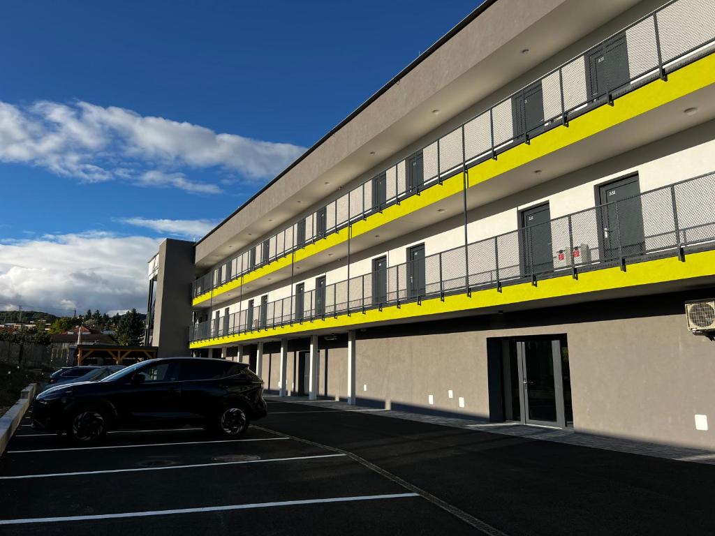 a black car parked in a parking lot next to a building at Bi Apartments in KoÅ¡ickÃ© KÃºpele