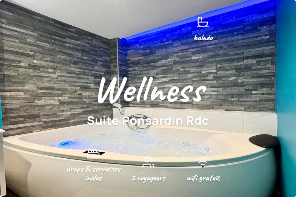 a bathroom with a tub and a sign that reads wellness at Wellness Suite Ponsardin RDC - Reims Centre in Reims
