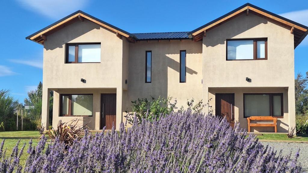 a house with purple flowers in front of it at Jardín de Estepa in Dina Huapi